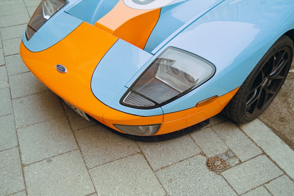 a blue and orange sports car parked on the side of the road