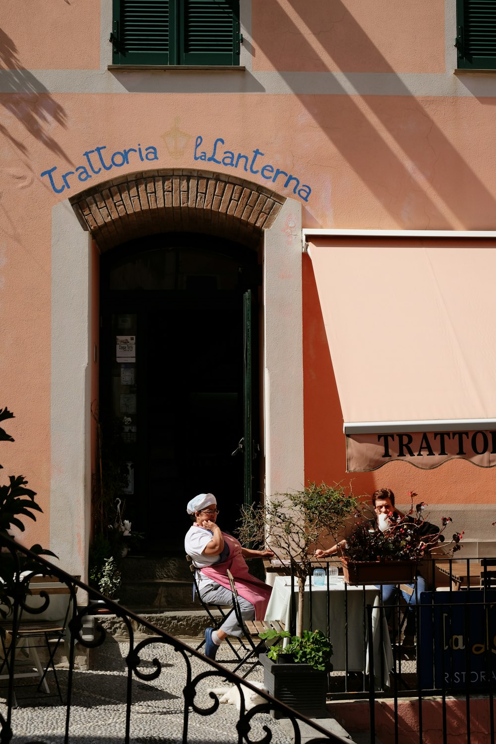 a woman sitting on a bench in front of a building