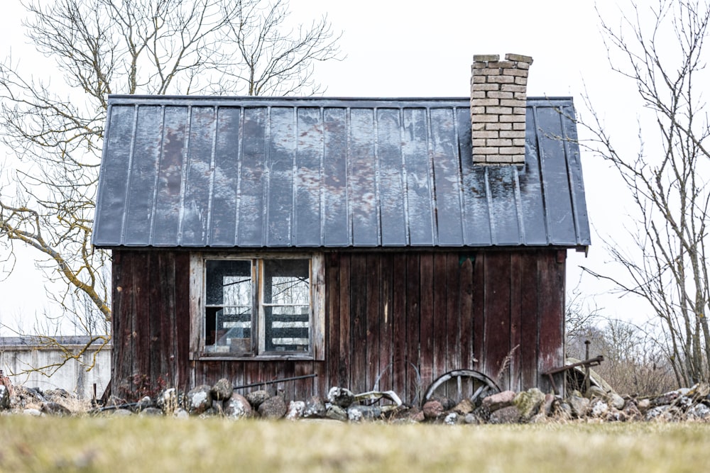 an old barn with a window and a rusty roof