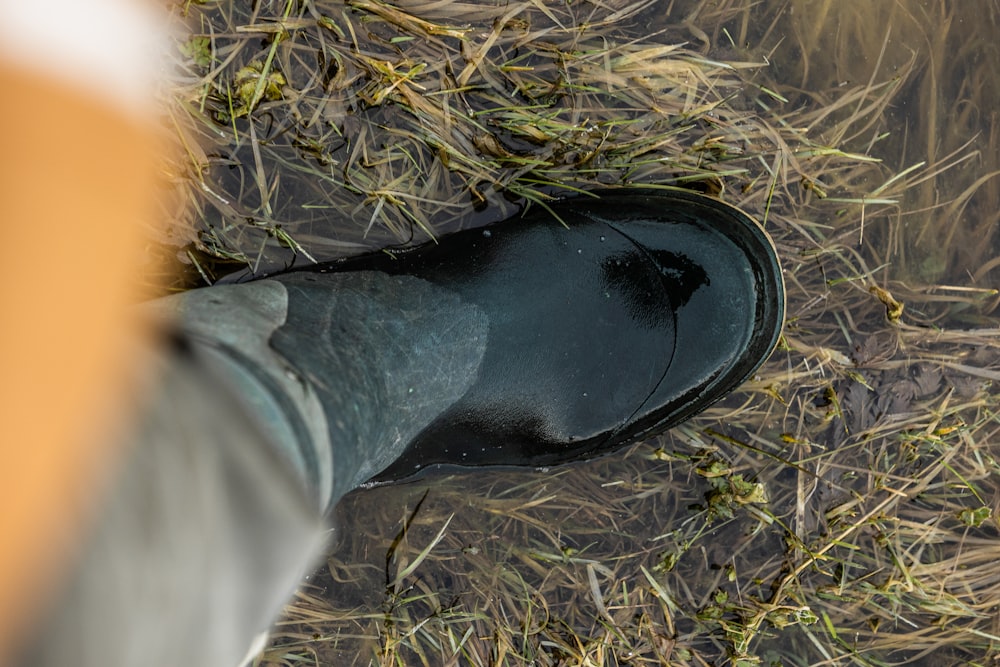 a person wearing black shoes standing in a field