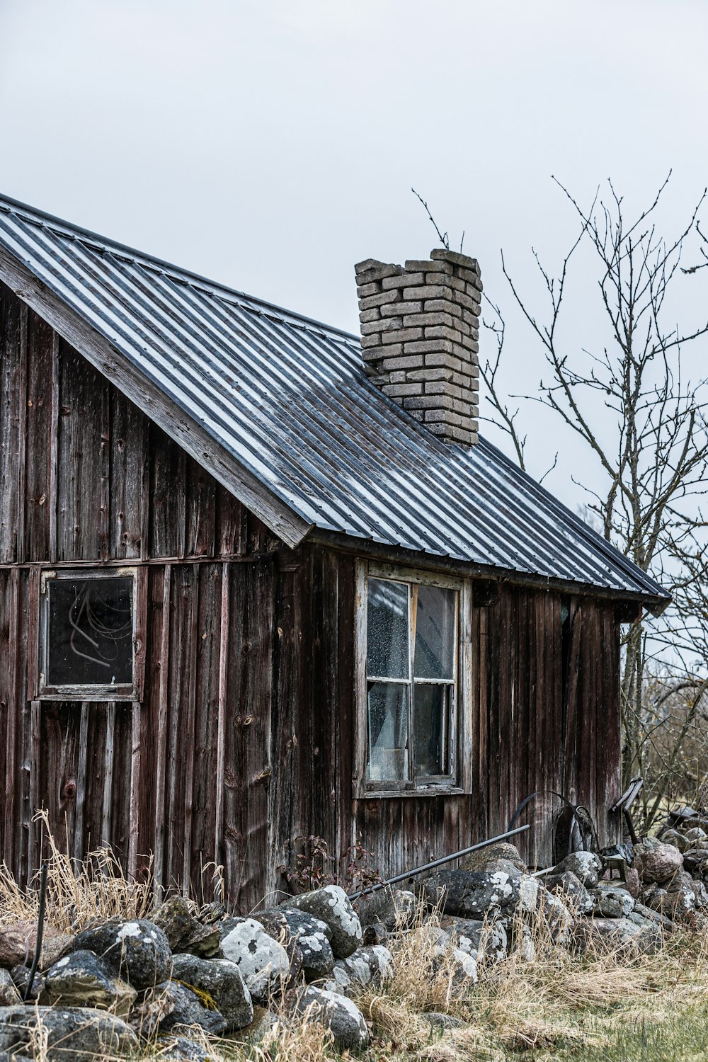 uma casa de madeira velha com um telhado de metal
