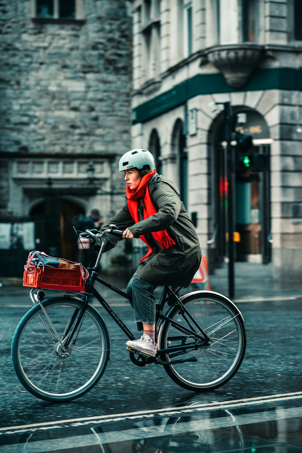 a man riding a bike down a street next to a tall building