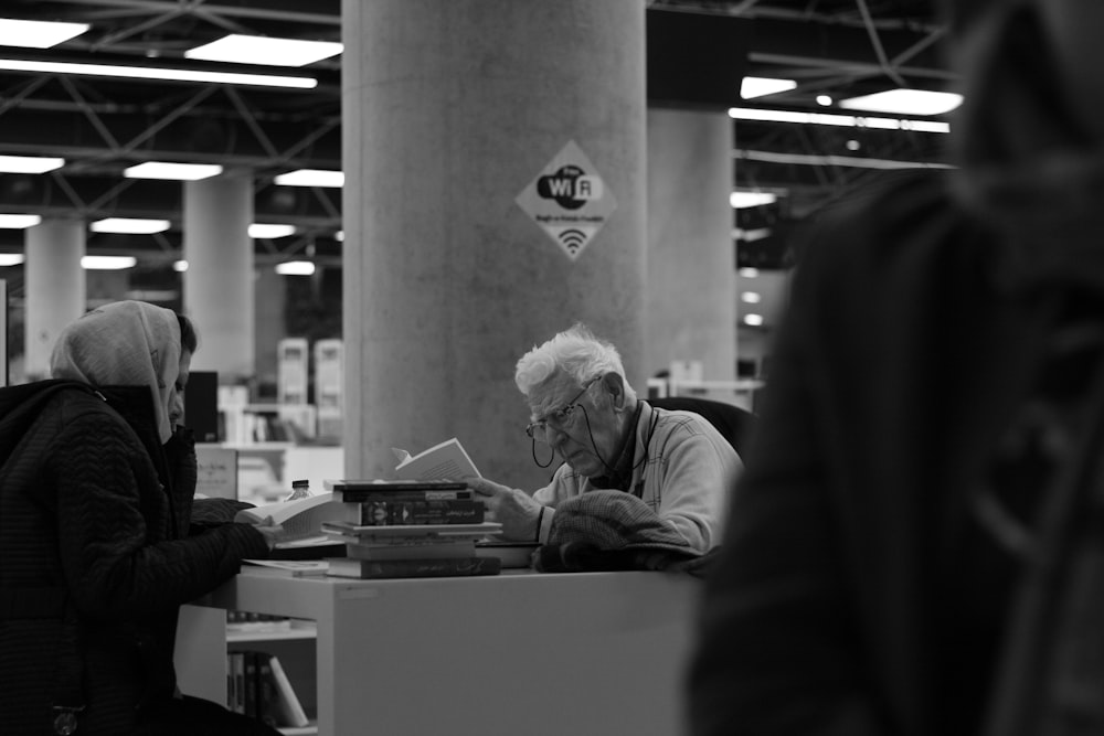 a black and white photo of a man sitting at a desk