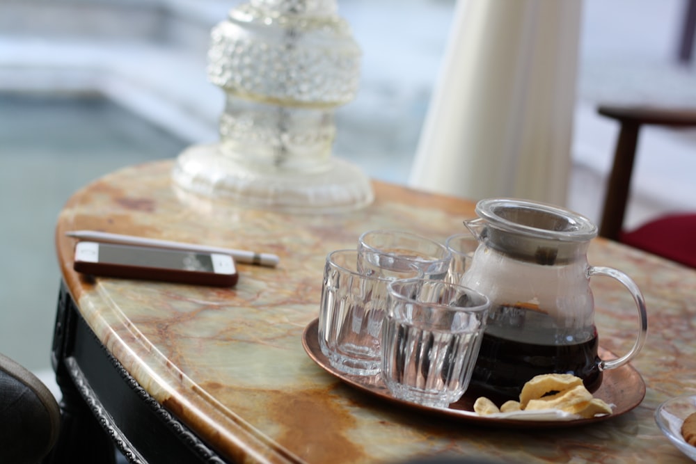 a table with a plate of food and glasses on it