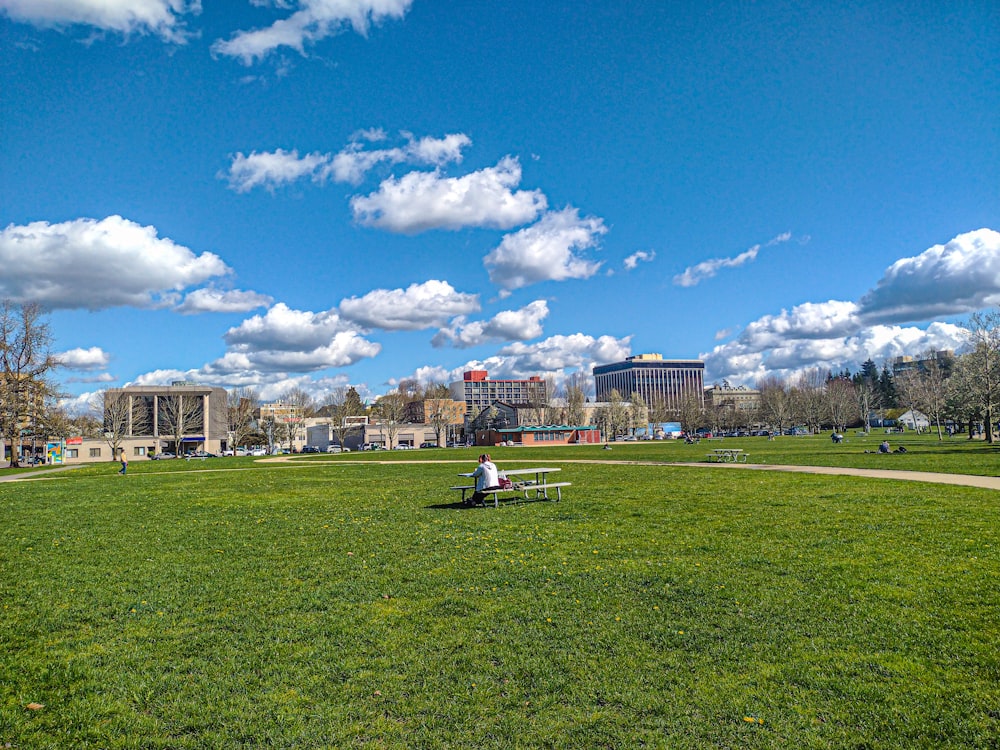 a man sitting on a bench in a park