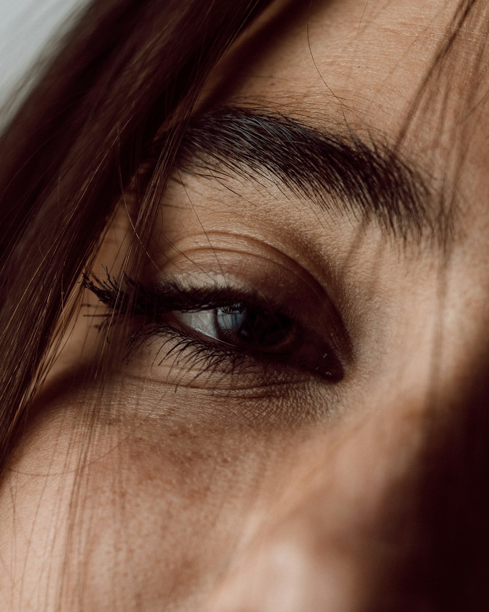 a close up of a person's eye with long hair