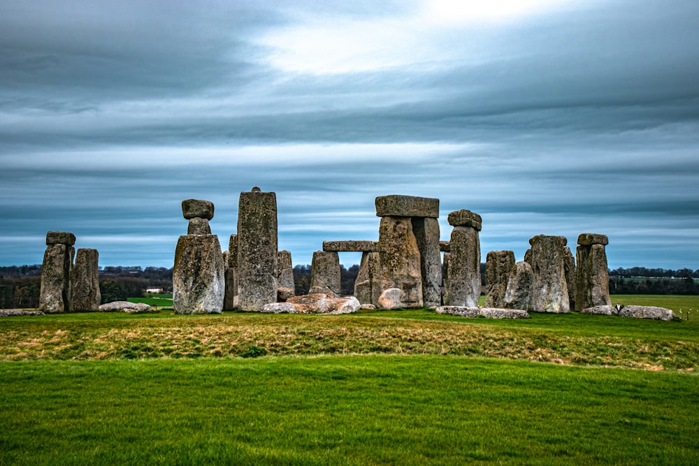 a group of stonehenge standing in a grassy field