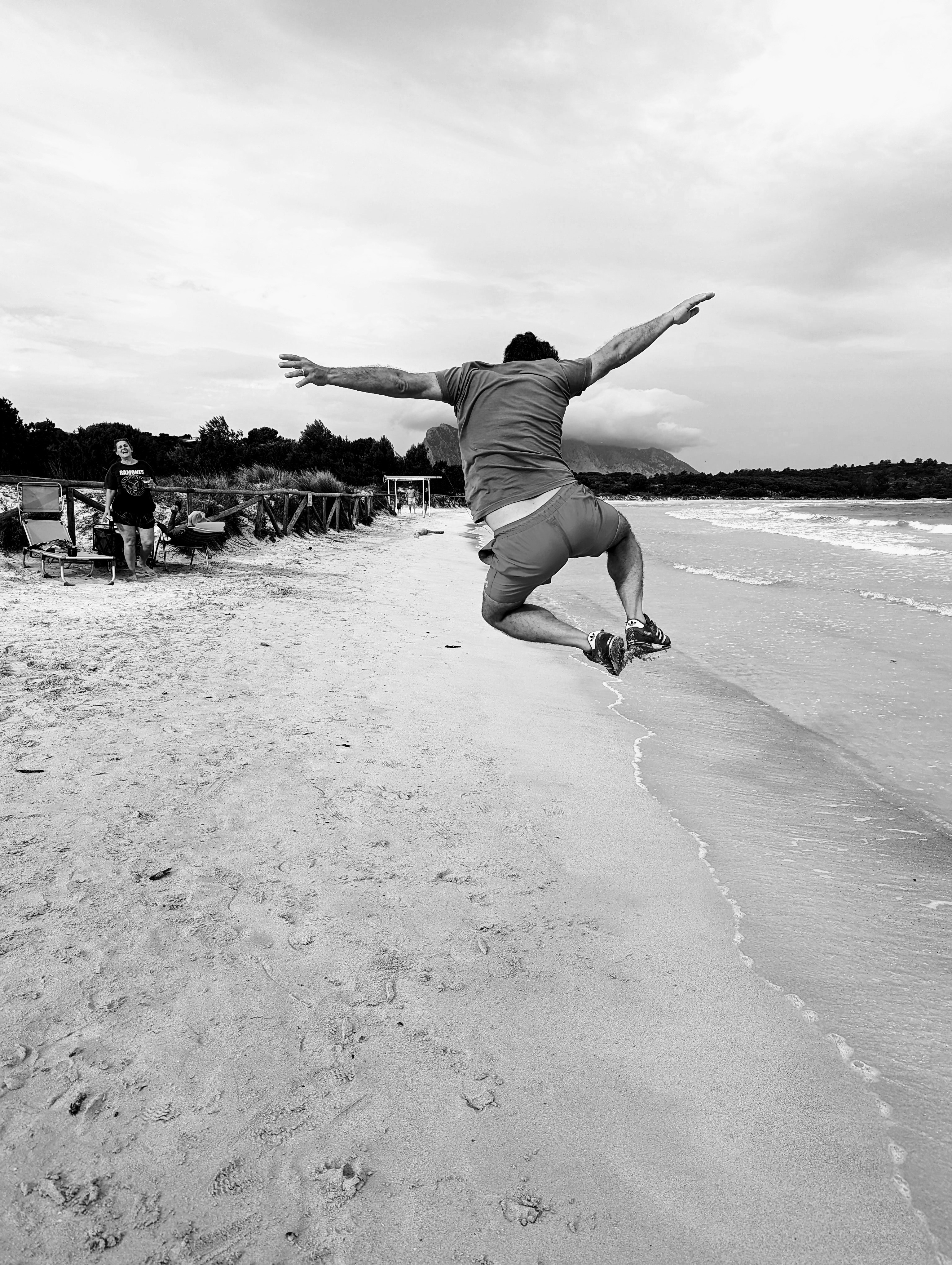 a man jumping in the air on a beach
