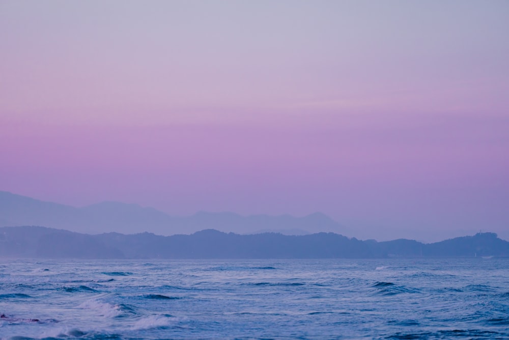 a body of water with mountains in the background