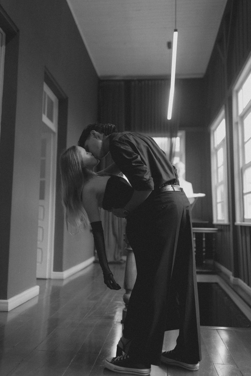 a man and a woman kissing in a room