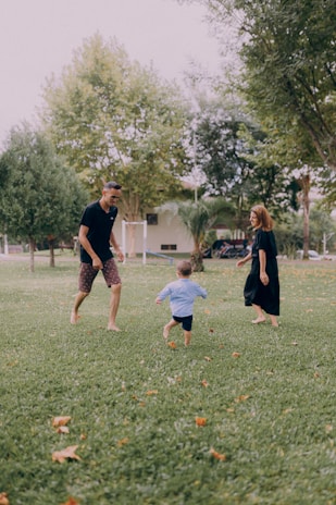 a man and a woman playing frisbee with a child