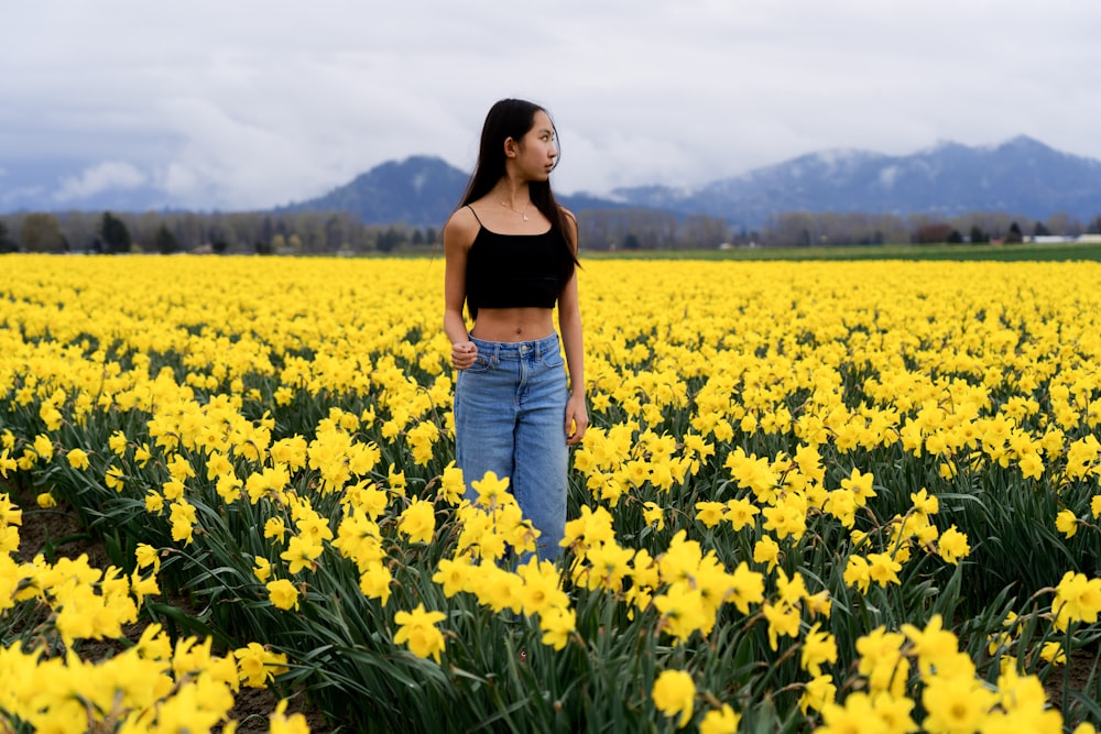 a woman standing in a field of yellow flowers