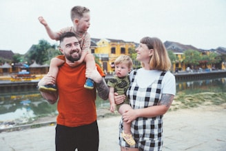 a man holding a child while standing next to two women and a child