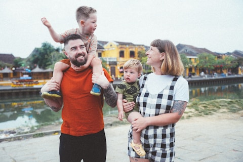 a man holding a child while standing next to two women and a child