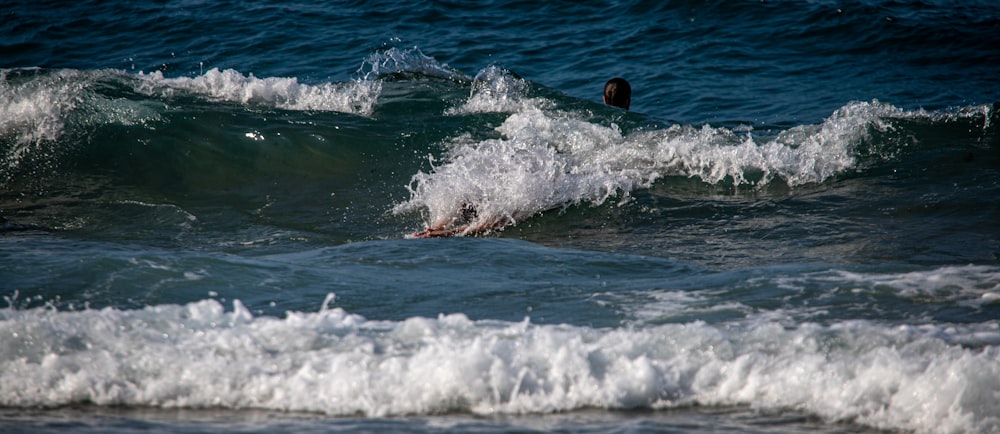uma pessoa deitada em uma prancha de surf no oceano