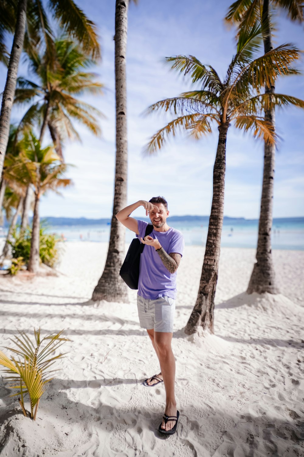 a man standing on a beach next to palm trees