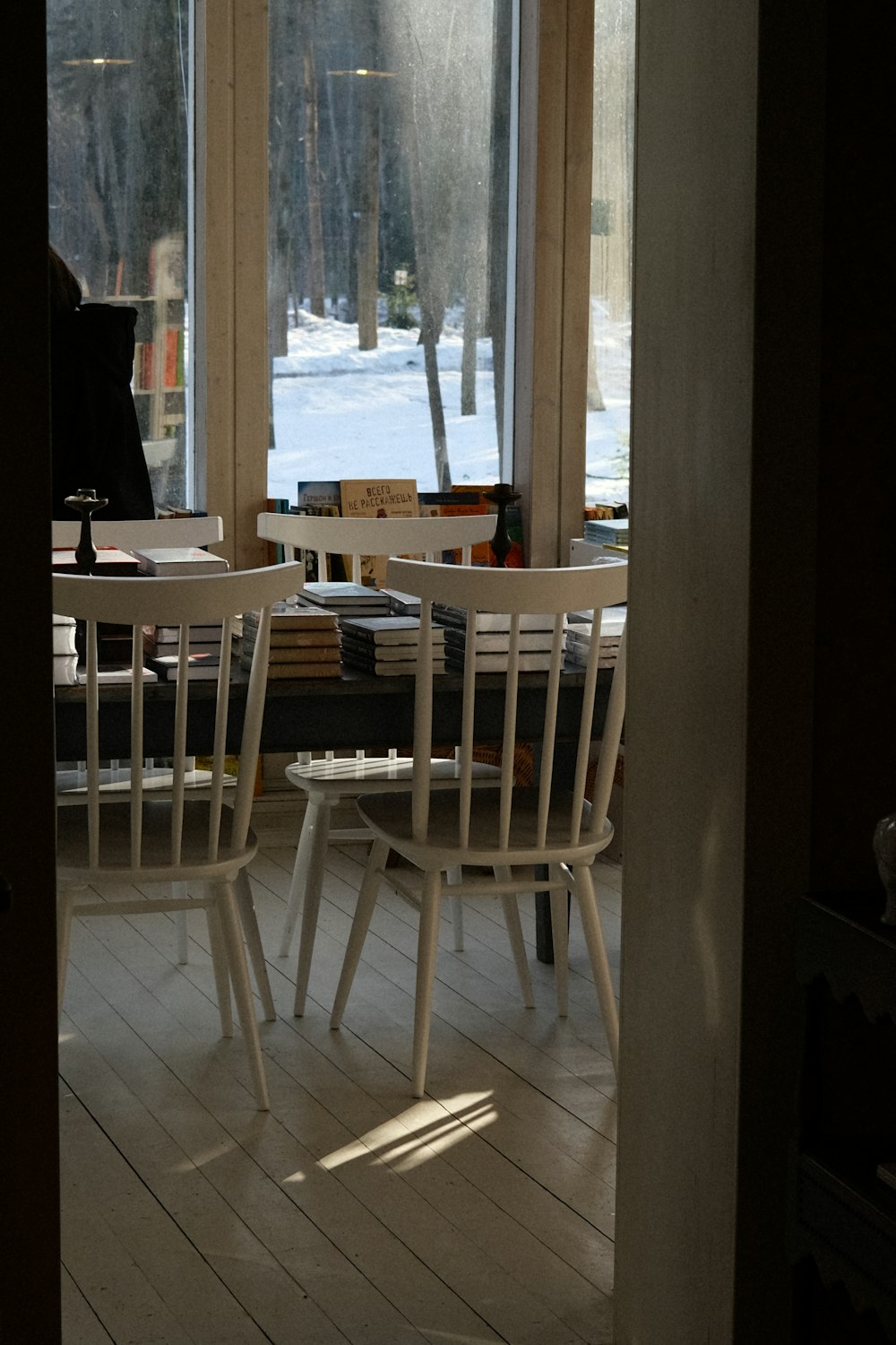 two white chairs sitting in front of a window