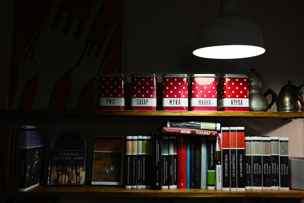 a bookshelf filled with lots of books next to a lamp