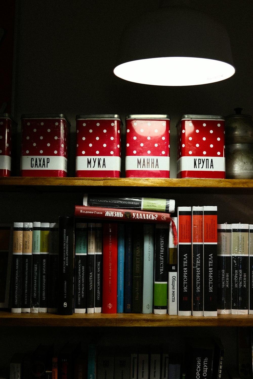 a bookshelf filled with lots of books next to a lamp