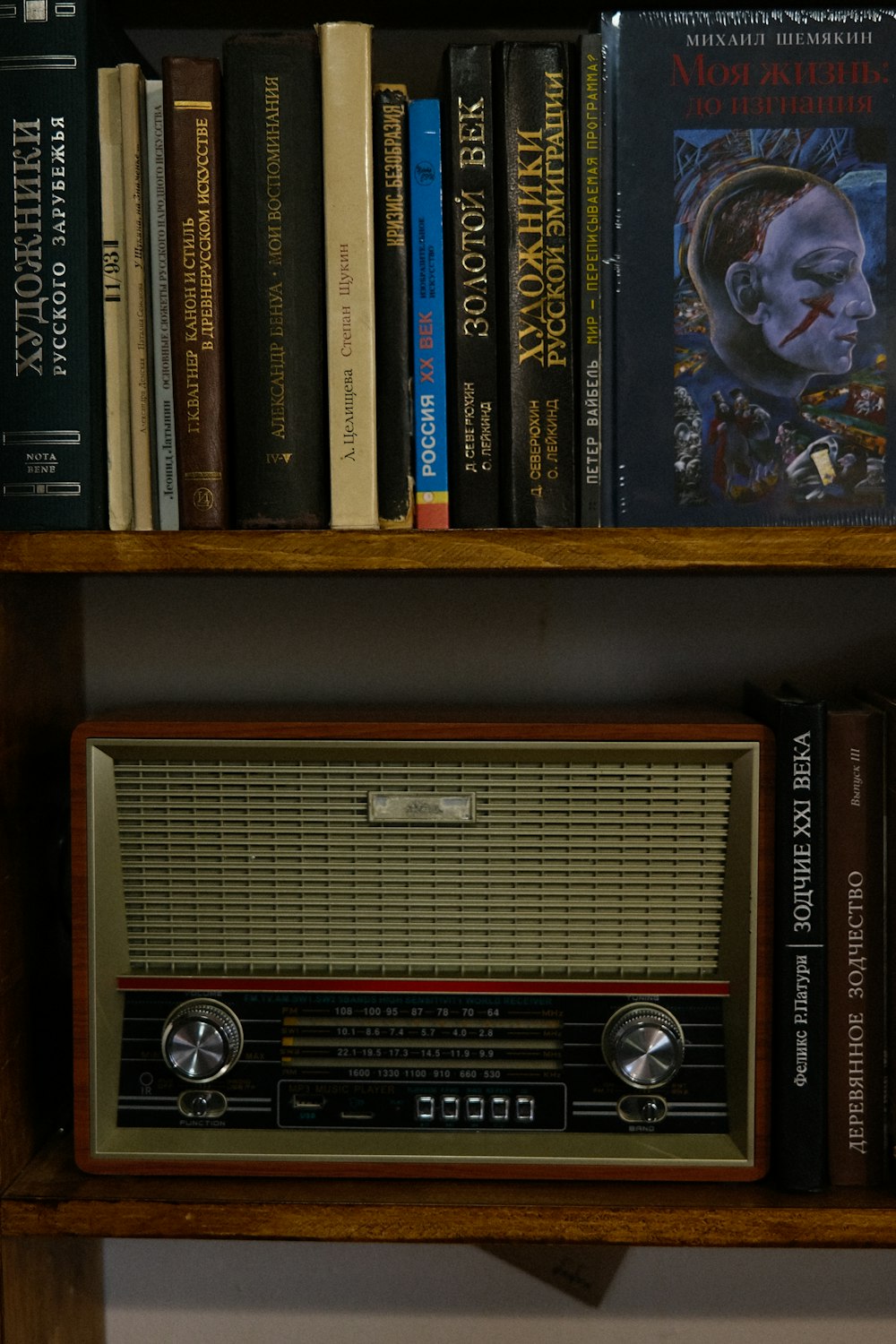 a book shelf with books and a radio on it