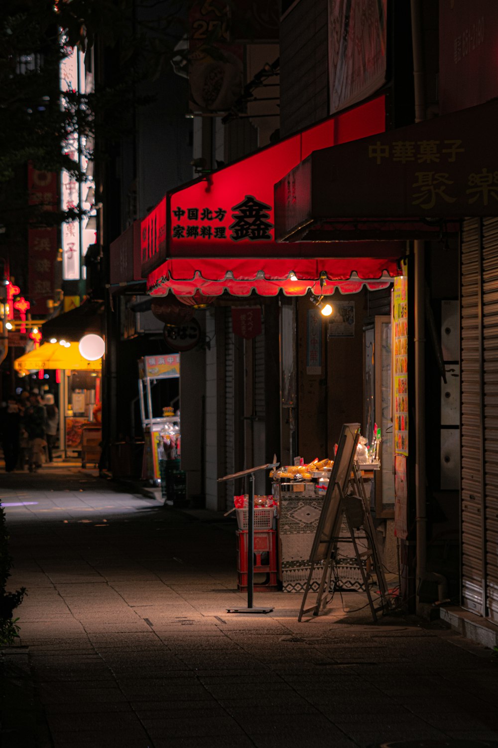 a dark street with a red awning over it