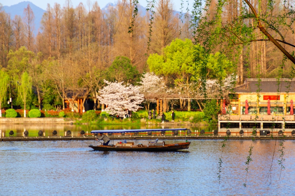 a boat floating on top of a lake next to a forest