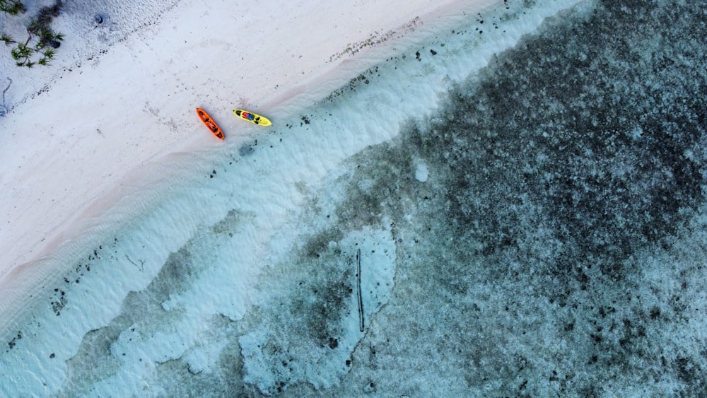 an aerial view of two kayaks on a beach