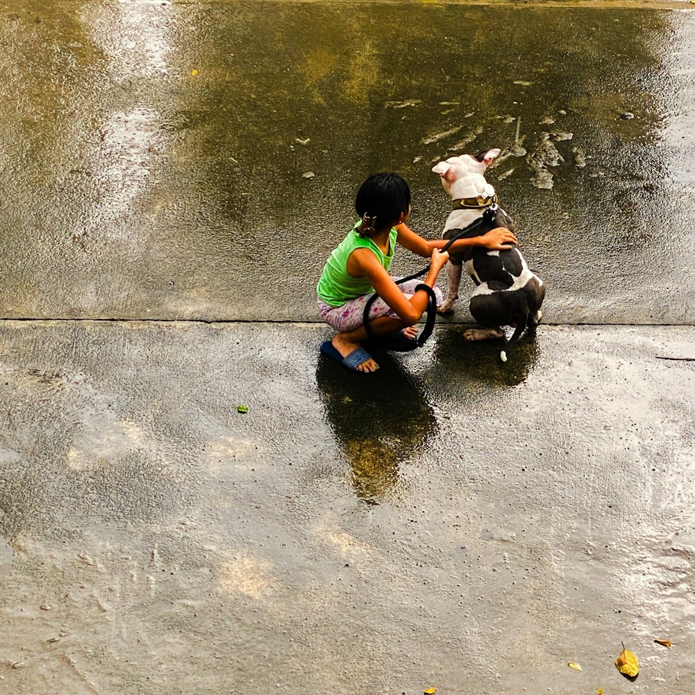 a little girl playing with a dog in the rain