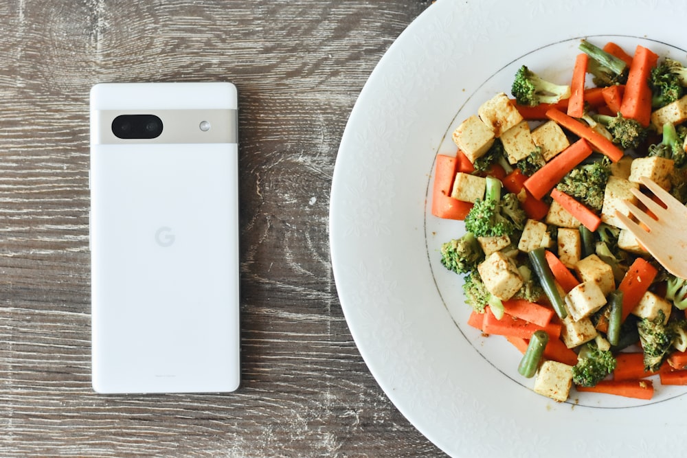 a plate of food with a cell phone next to it