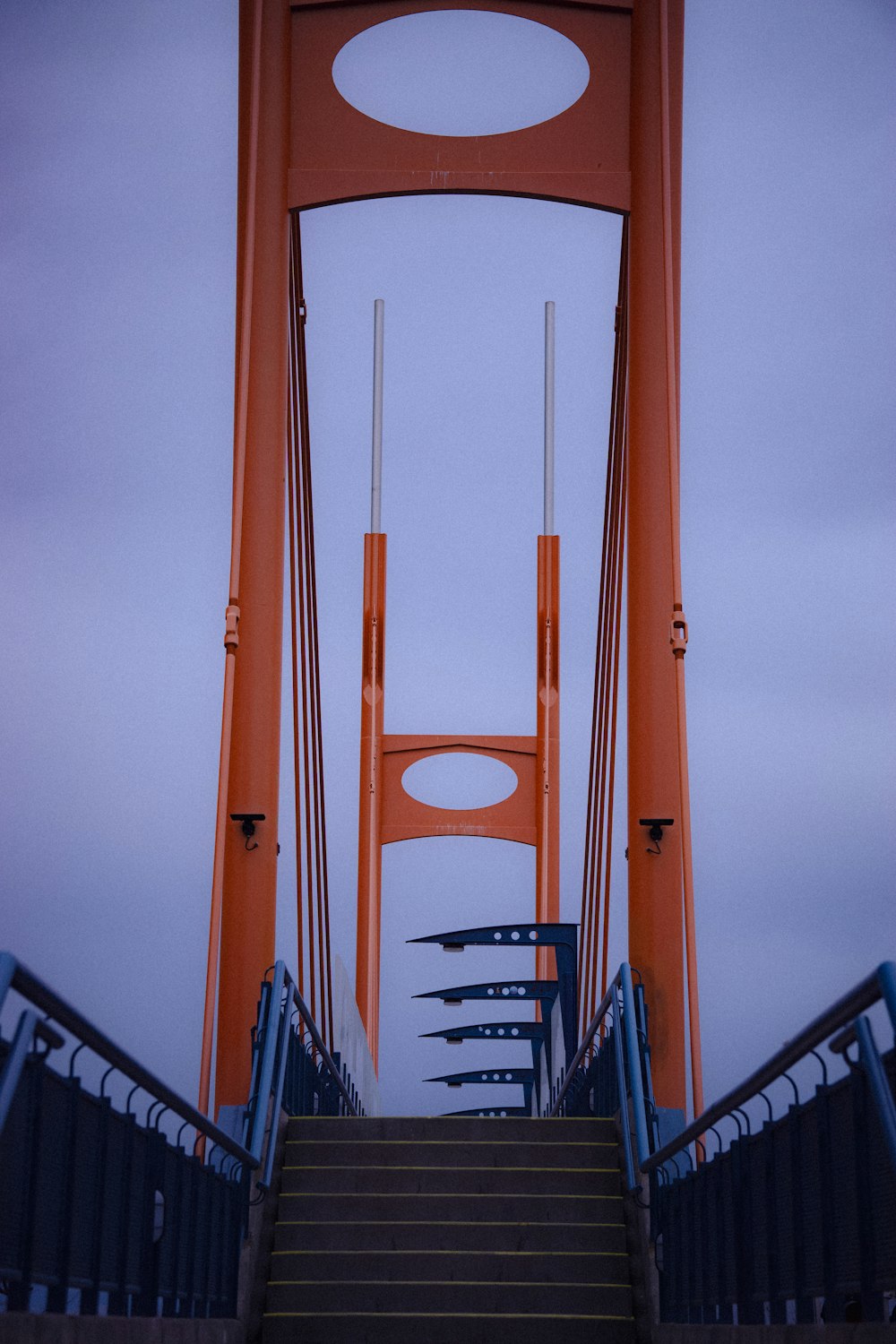 a very tall orange bridge with a bunch of stairs