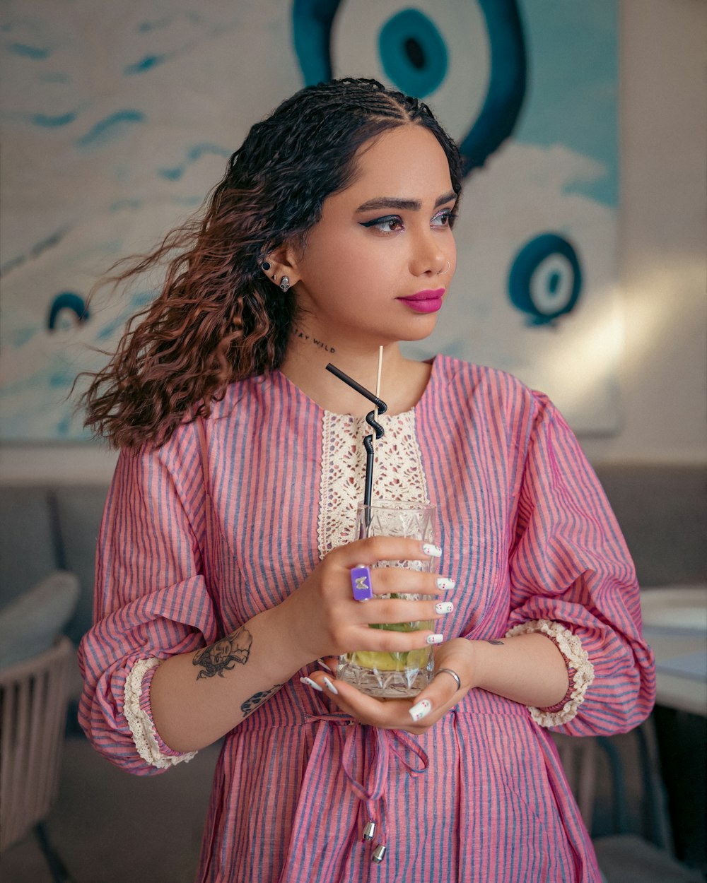 a woman in a pink dress holding a drink