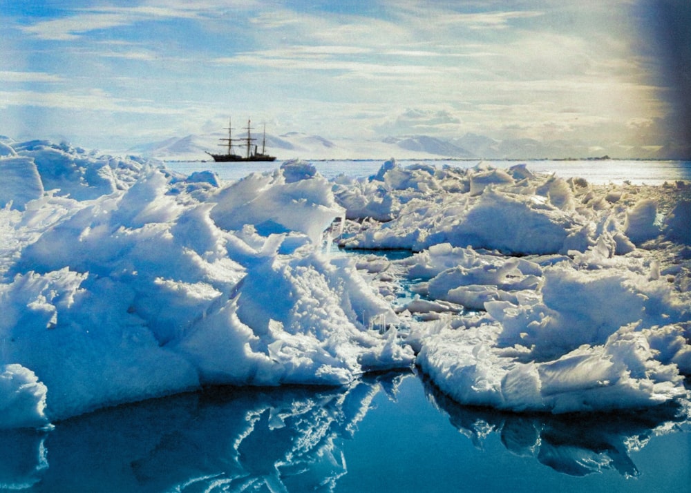 a boat floating on top of a body of water surrounded by ice