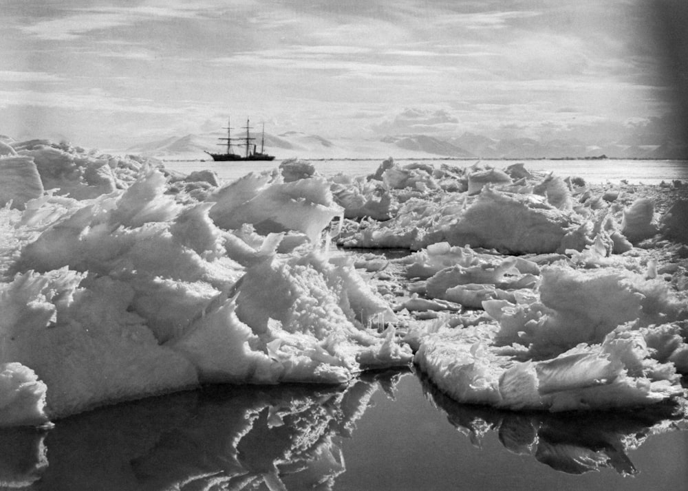 a ship sailing in the ocean near icebergs