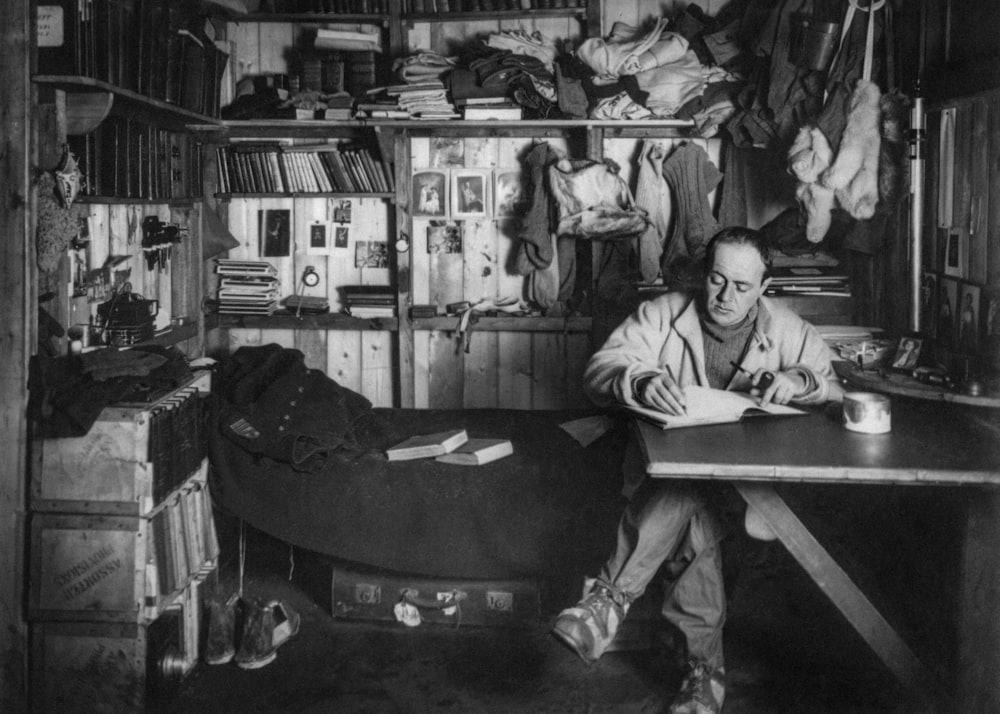 a black and white photo of a man sitting at a desk