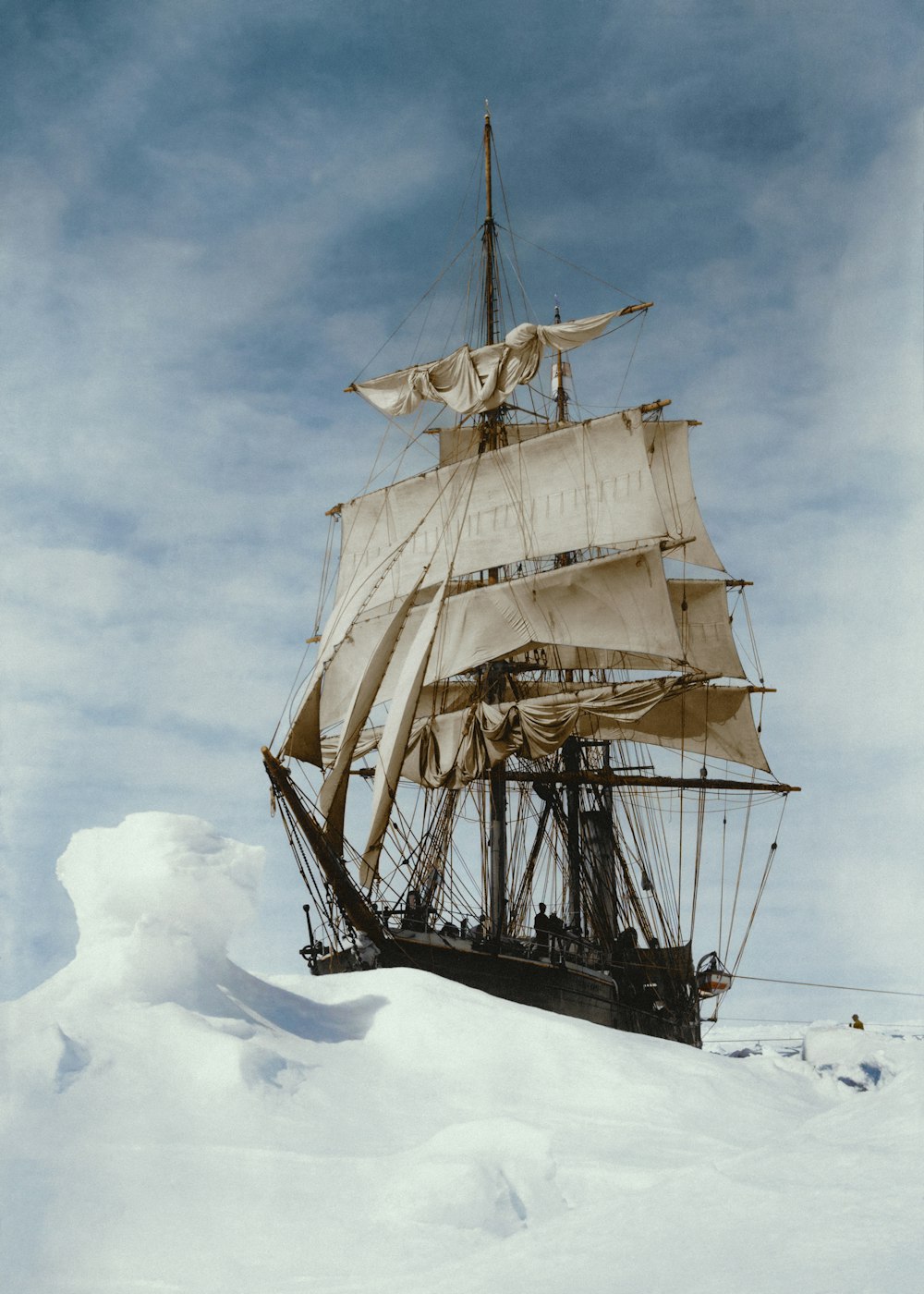 a large white sail boat floating on top of snow covered ground
