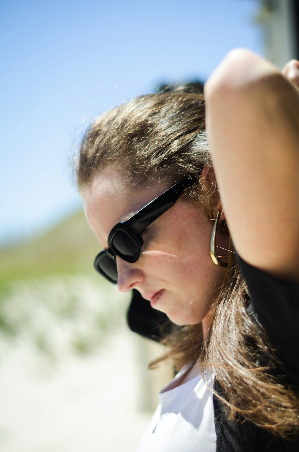 a woman wearing sunglasses and a white shirt