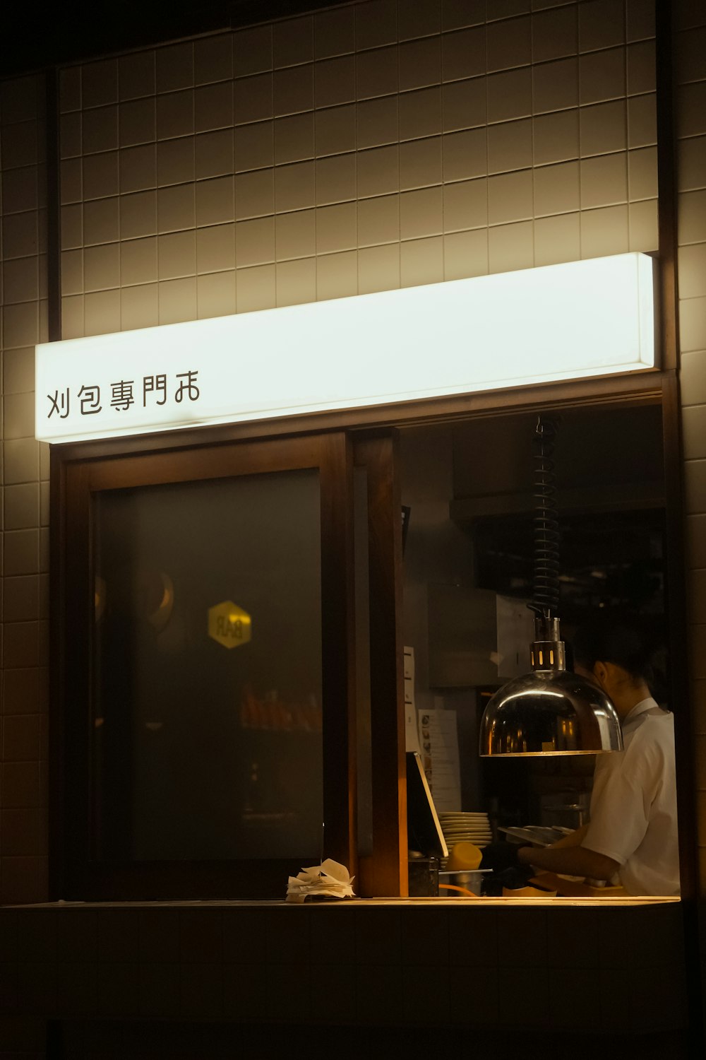 a man standing in front of a counter in a restaurant