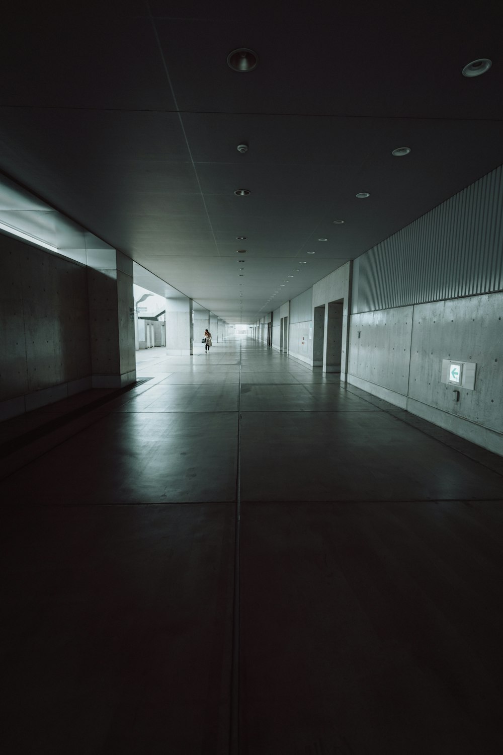 a dark hallway with a person walking down it