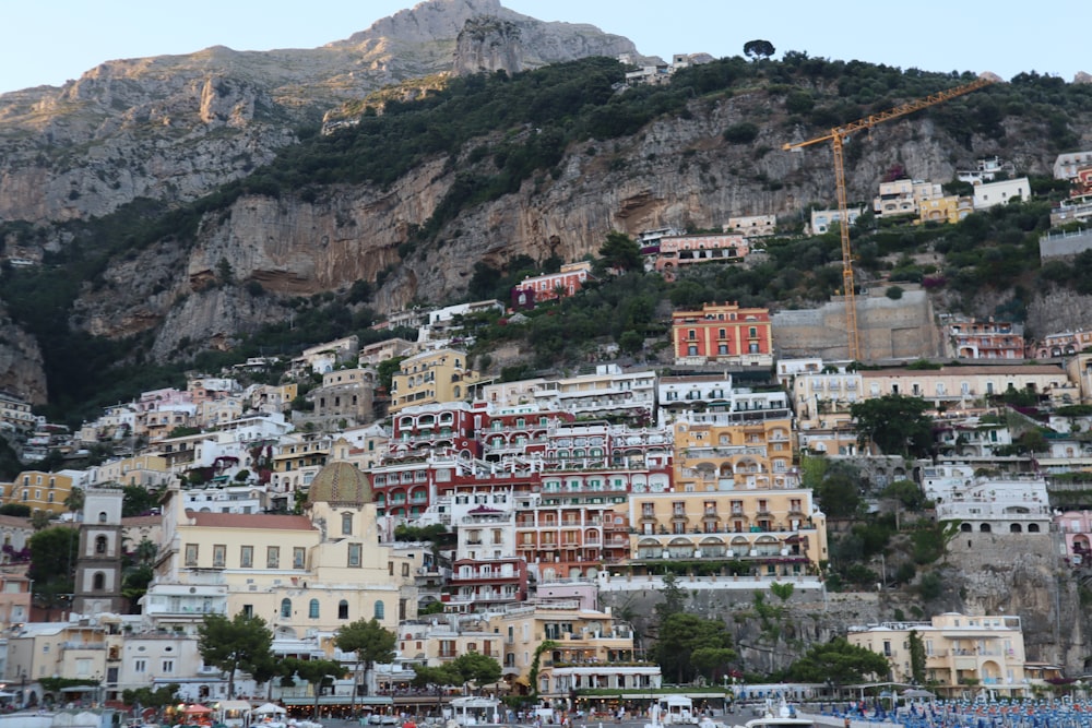 una ciudad en la ladera de una montaña junto a un cuerpo de agua