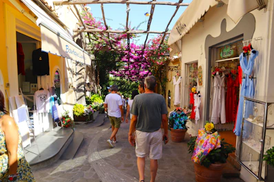 a group of people walking down a street next to a store