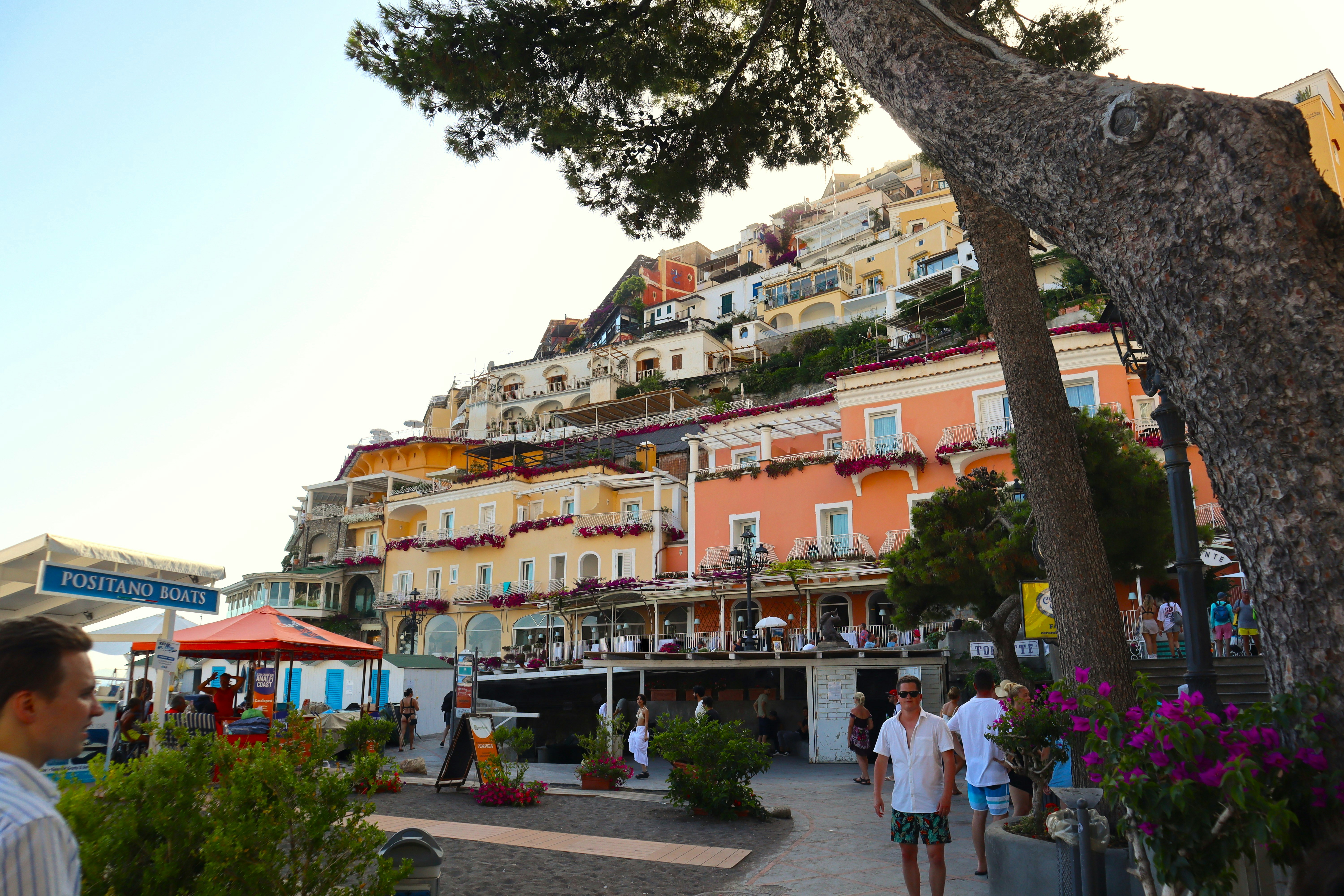 a group of people walking down a street next to a tall building, 