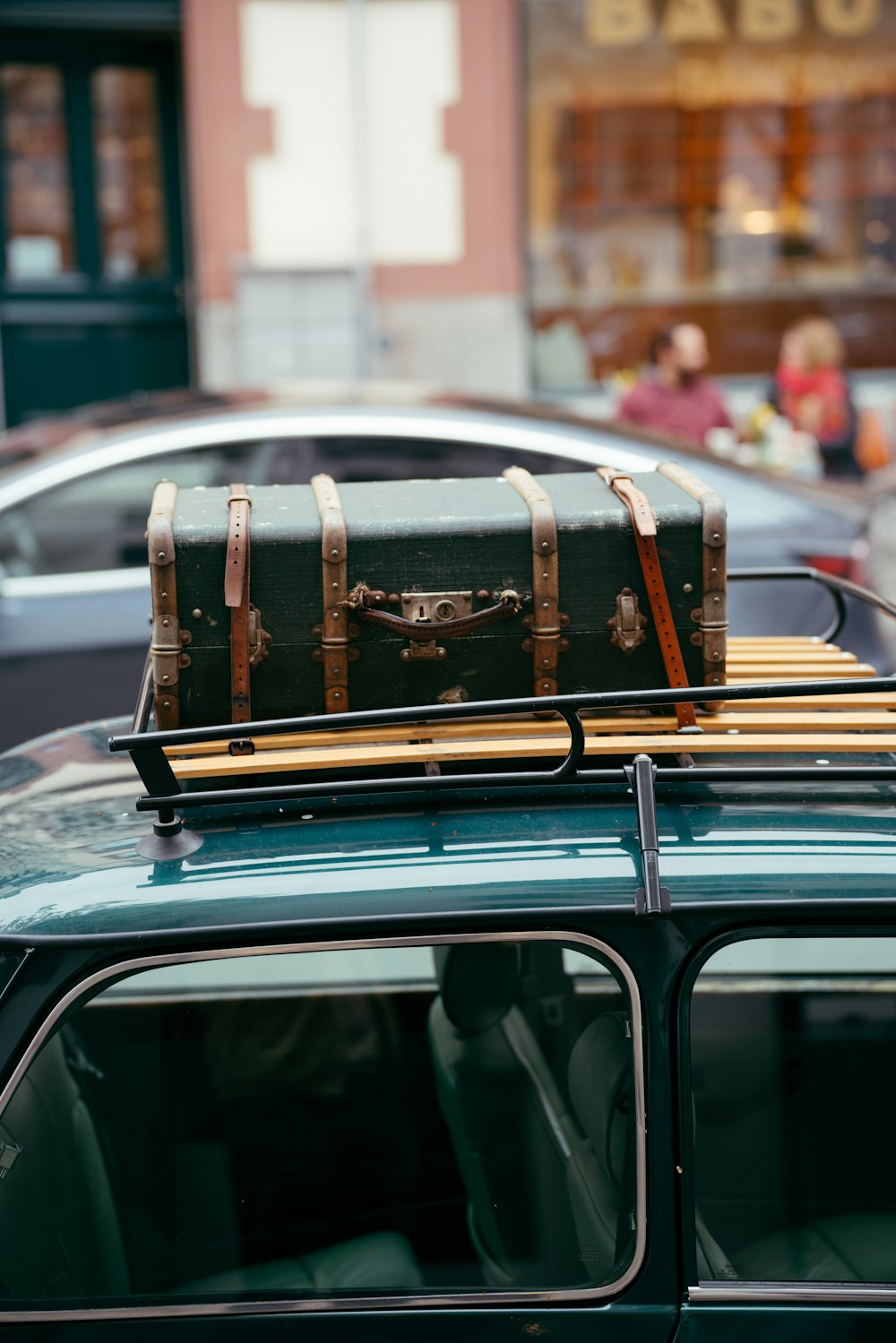 a trunk sitting on top of a green car