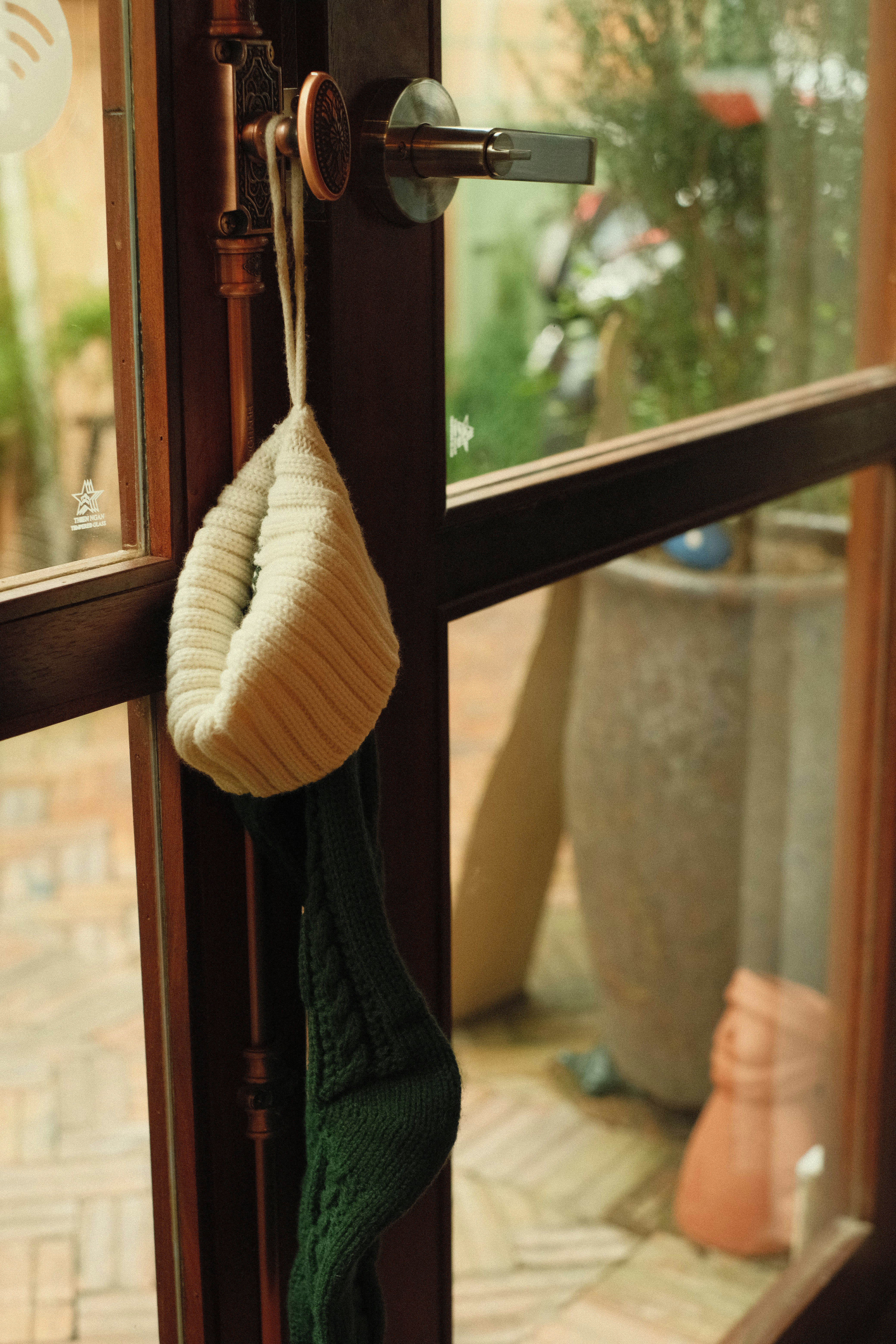 a green sweater hanging from a hook on a door