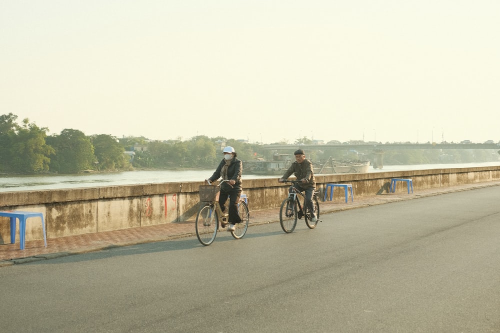 a couple of people riding bikes down a street