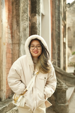 A woman standing in front of a brick building
