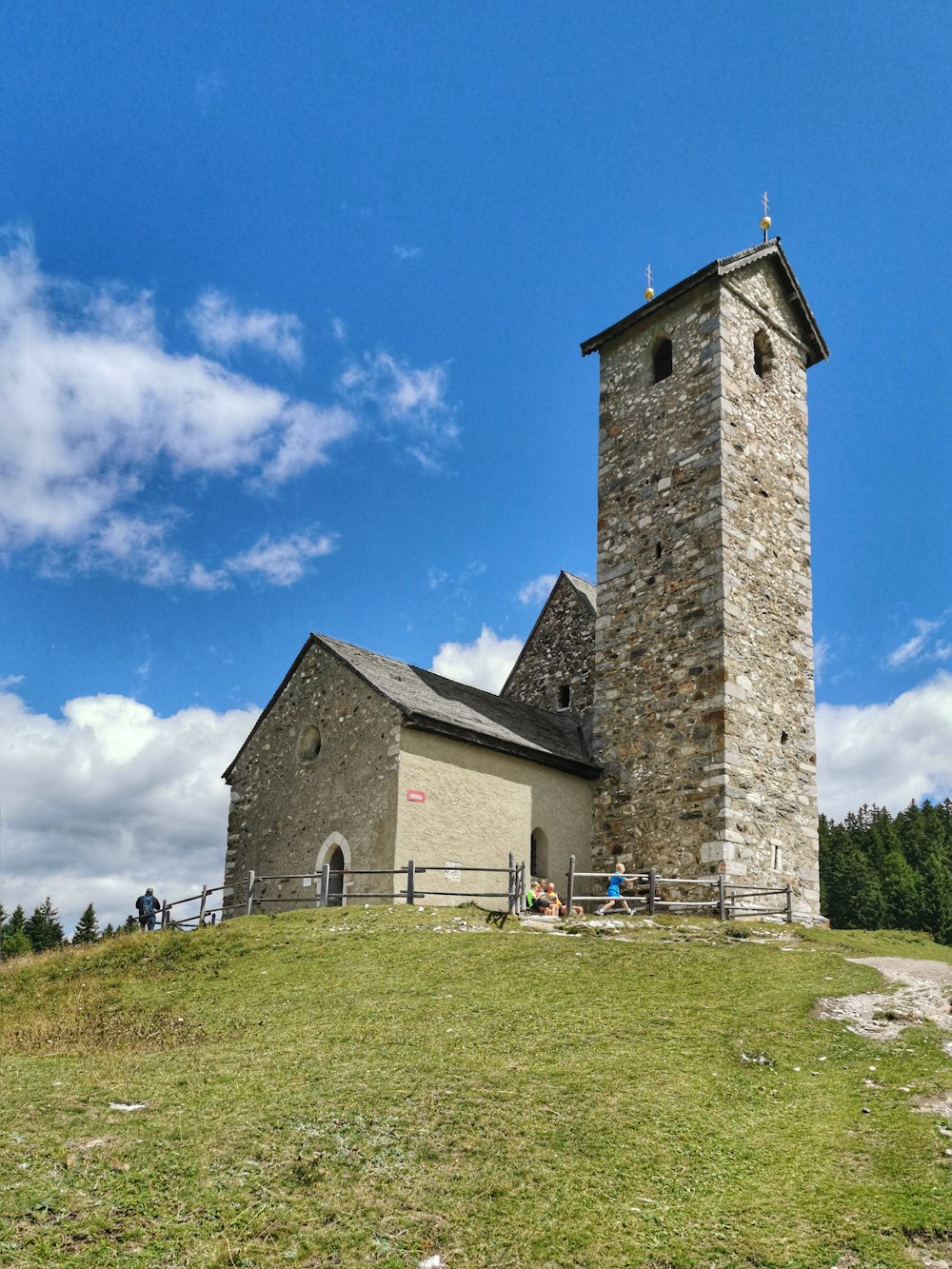 a stone church with a steeple on top of a hill