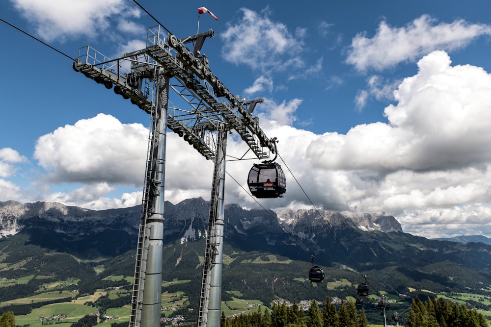 a ski lift going up a mountain with mountains in the background