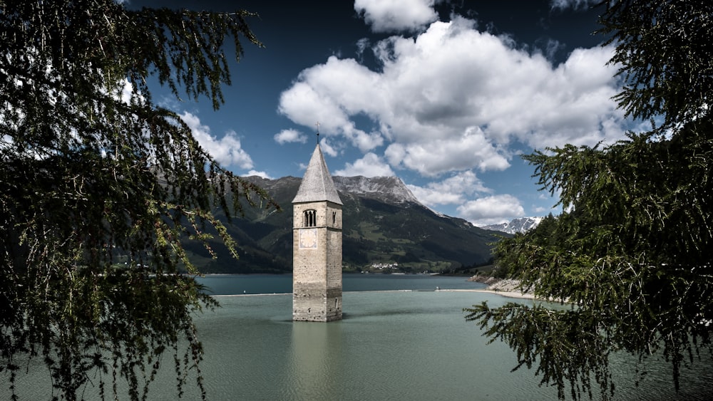 a clock tower sitting in the middle of a lake