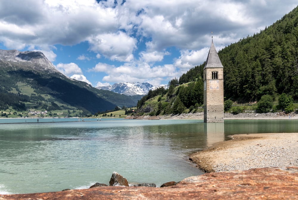 a clock tower sitting on the edge of a lake