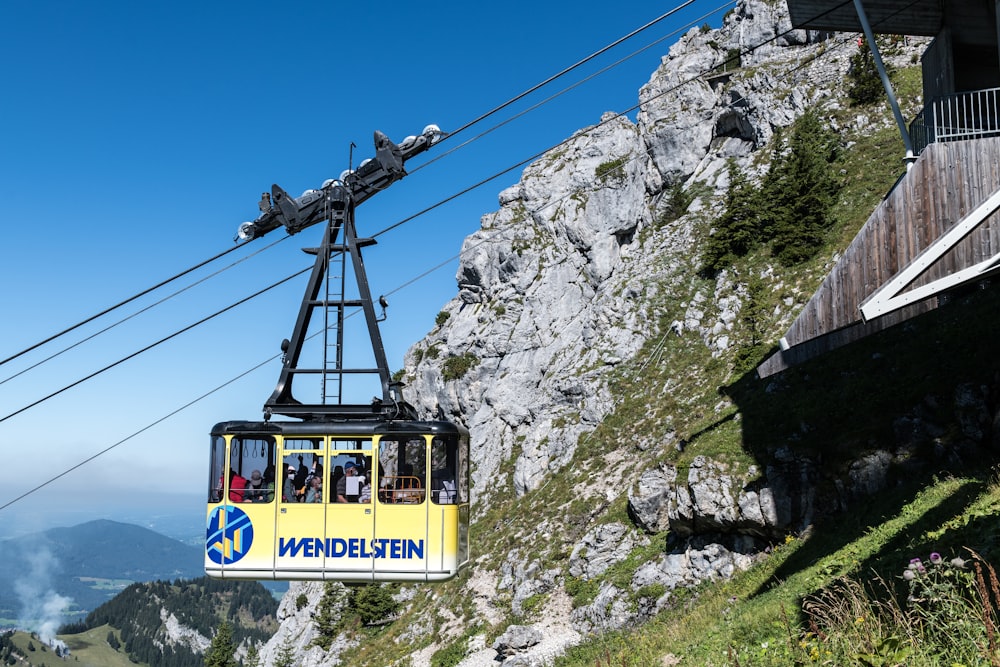 a cable car with passengers going up a mountain